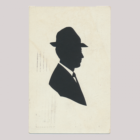 
        Front of silhouette, with man looking right, in suit wearing a hat.